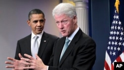 President Barack Obama looks on as former President Bill Clinton speaks in the briefing room of the White House in Washington, Friday, Dec. 10, 2010.