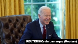 Presiden AS, Washington, AS Joe Biden tersenyum setelah menandatangani perintah eksekutif yang memperkuat akses ke perawatan kesehatan yang terjangkau. (Foto: REUTERS/Kevin Lamarque)