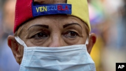 Una manifestante usa una máscara quirúrgica durante una protesta para exigir que el gobierno atienda la crisis de salud en Venezuela.