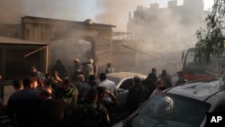 Security officers and rescuers gather at a building destroyed in an Israeli airstrike in Damascus, Syria, on Nov. 14, 2024.