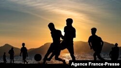 Youths play soccer along a beach as the sun sets in Banda Aceh, Indonesia.
