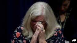 Judy Deaven who says her son was a victim of sexual abuse by a priest as a boy reacts as Pennsylvania Attorney General Josh Shapiro speaks during a news conference at the Pennsylvania Capitol in Harrisburg, Pa., Tuesday, Aug. 14, 2018. A Pennsylvania grand jury says its investigation of clergy sexual abuse identified more than 1,000 child victims. The grand jury report released Tuesday says that number comes from records in six Roman Catholic dioceses.