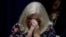 Judy Deaven who says her son was a victim of sexual abuse by a priest as a boy reacts as Pennsylvania Attorney General Josh Shapiro speaks during a news conference at the Pennsylvania Capitol in Harrisburg, Pa., Tuesday, Aug. 14, 2018. A Pennsylvania grand jury says its investigation of clergy sexual abuse identified more than 1,000 child victims. The grand jury report released Tuesday says that number comes from records in six Roman Catholic dioceses.