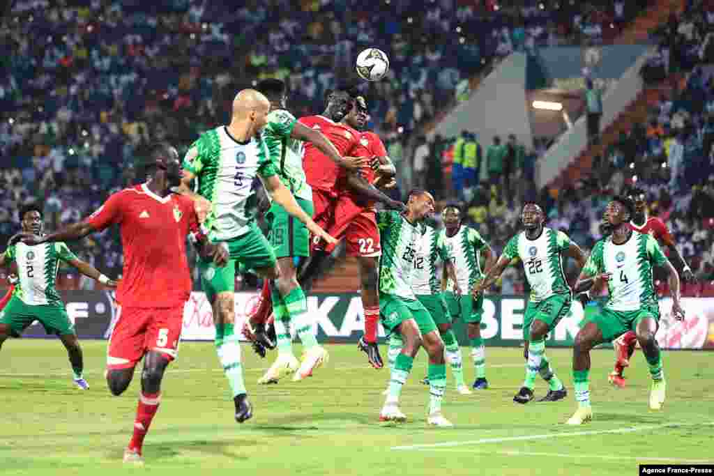 Nigeria&#39;s midfielder Frank Onyeka (C) and Sudan&#39;s midfielder Al Gazoli Hussein Nooh (C-R) jump for the ball with Nigeria&#39;s forward Taiwo Awoniyi (C-L) during the football match between Nigeria and Sudan.