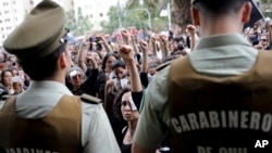 An anti-government demonstrators wearing patches on their faces raise their fists during a women's march against President Sebastian Pinera in Santiago, Chile, Nov. 1, 2019.