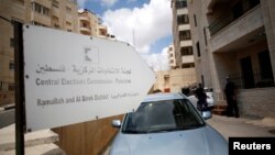 Palestinian policemen stand guard outside the headquarters of the Central Elections Commission in the West Bank town of El Bireh, Aug. 17, 2016.