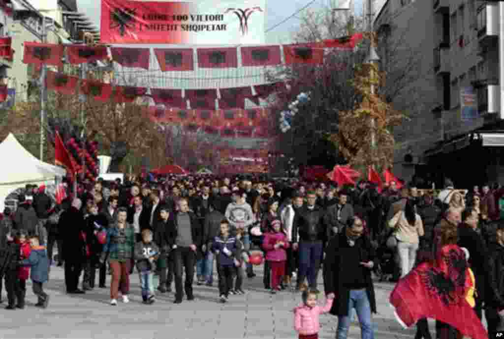 Kosovo Albanians walk in the main square decorated with Albanian flags in capital Pristina, Kosovo on Wednesday, Nov. 28, 2012. Albania is celebrating its 100th anniversary of independence with national flag blanketing city squares, apartment buildings 