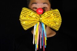 Edmond Kok, a Hong Kong theater costume designer and actor, wears a face mask modeled on a clown face and bow tie in Hong Kong, Aug. 6, 2020.