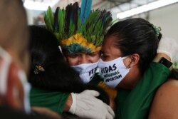 Para kerabat menangis saat pemakaman Pemimpin Umat Kokama Martins Moreira, yang meninggal karena Covid-19 di Pemakaman Khusus Bagi Warga Pribumi (Park of Indigenous Nations), Manaus, Brazil, 14 Mei 2020.