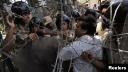 A member of the Muslim Brotherhood and supporter of ousted Egyptian President Mohamed Mursi shouts slogans and clashes with the army while trying to remove a barbed wire fence near Egypt's defense ministry headquarters in Cairo Jul. 21, 2013.