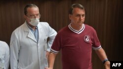 Brazil's President Jair Bolsonaro (R) is seen next to a doctor during a press conference at the Vila Nova Star Hospital after he was discharged, in Sao Paulo, Brazil, on Jan. 5, 2022. 