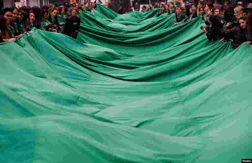Activists, part of a movement known as "Marea Verde" take part in a performance to film a message to spread awareness during the International Safe Abortion Day in Mexico City, Mexico, Sept. 28, 2019.