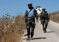 Irish U.N. peacekeepers use mine detectors as they patrol near the fields struck by Israeli army shells in the southern Lebanese-Israeli border village of Maroun el-Ras, Lebanon, Sept. 2, 2019.