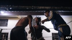 FILE - Voodoo wrestler Maitresse Libondans faces off with her opponent and a referee in a schoolyard in Selemenbao district in Kinshasa, on July 29, 2023. 