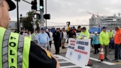 Para pekerja pelabuhan melakukan aksi mogok di depan pintu masuk terminal peti kemas dekat Pelabuhan Boston, Selasa, 1 Oktober 2024, di Boston. (Steven Senne/AP)