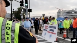 Para pekerja pelabuhan melakukan aksi mogok di depan pintu masuk terminal peti kemas dekat Pelabuhan Boston, Selasa, 1 Oktober 2024, di Boston. (Steven Senne/AP)