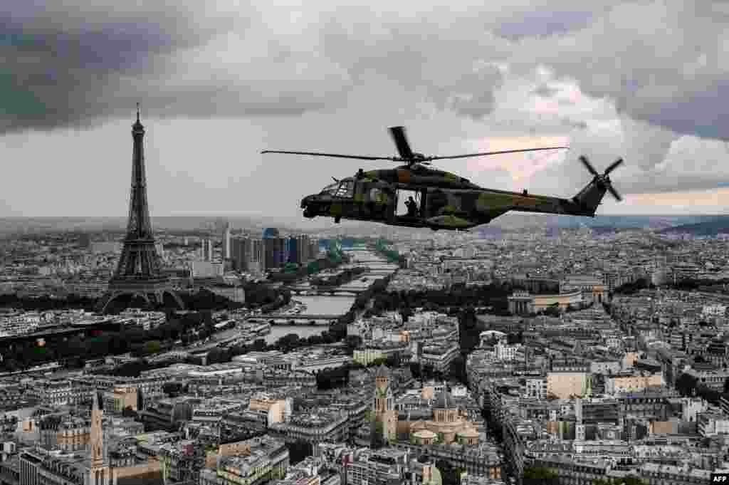 An NH90 &quot;CAIMAN&quot; helicopter flies over the Eiffel Tower and the Seine river during a practice session prior to July 14&#39;s Bastille Day Parade in Paris, France.