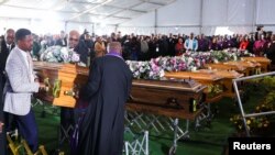 FILE: Mourners place empty coffins ahead of a mass funeral for 21 victims of an east coast tavern where bodies of youth were found in East London, South Africa, 7.6.2022