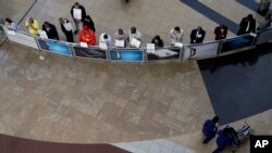 Hotel and taxi representative stand in front of the arrival gate at O.R. Tambo International airport in Johannesburg Aug. 25, 2014.