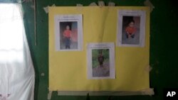 A poster with photocopies that show Felipe Gomez Alonzo is taped to a wall as part of a makeshift memorial honoring the 8-year-old, inside his mother's home in Yalambojoch, Guatemala, Dec. 29, 2018. 