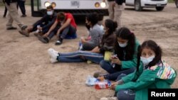 Menores no acompañadas que viajan solas desde Honduras, se sientan entre otros niños solicitantes de asilo mientras esperan ser transportados a una instalación de procesamiento de la patrulla fronteriza de EE. UU., el 6 de mayo de 2021.