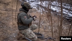 Seorang anggota pasukan Ukraina tampak menyiapkan sistem satelit internet Starlink di garis depan pertempuran di Kota Avdiivka, Ukraina, pada 20 Februari 2024. (Foto: Reuters/Inna Varenytsia)