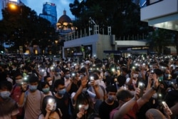 Pro-democracy demonstrators march holding their phones with flashlights on during a protest to mark the first anniversary of a mass rally against the now-withdrawn extradition bill, in Hong Kong, China, June 9, 2020.