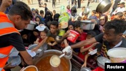 فلسطینی‌هایی که خانه‌های خود را ترک کرده‌اند برای دریافت غذای خیریه در رفح جمع شده‌اند.