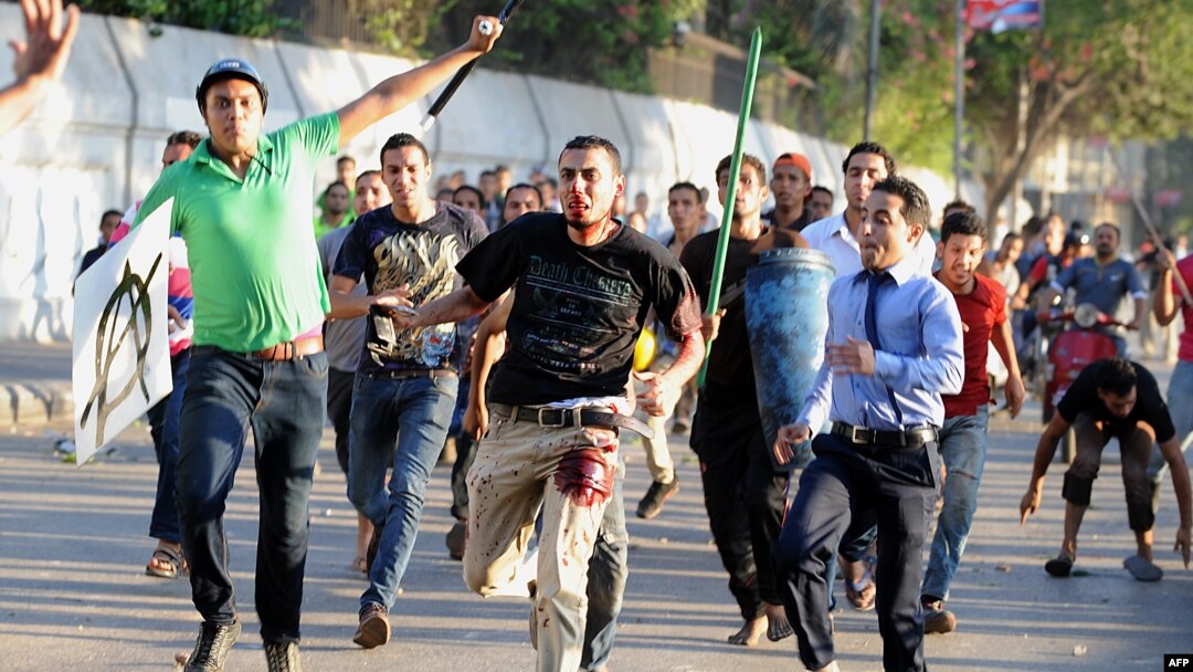 Supporter of ousted Egyptian President Mohamed Morsi is beaten by pro-government and army supporters during clashes that erupted at Tahrir Square and near the U.S. Embassy in Cairo, July 22, 2013.