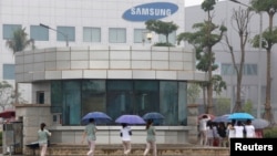 FILE - Employees make their way to work at the Samsung factory in Thai Nguyen province, north of Hanoi, Vietnam, Oct. 13, 2016. 