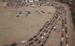 Gambar yang diambil dari udara tampak antrean mobil mengular di luar lokasi tes Covid-19 di Stadium Dodger, Los Angeles, California, 18 November 2020.