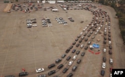Gambar yang diambil dari udara tampak antrean mobil mengular di luar lokasi tes Covid-19 di Stadium Dodger, Los Angeles, California, 18 November 2020.