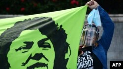 Una mujer sostiene una pancarta que representa a la ambientalista hondureña Berta Cáceres durante una protesta contra el gobierno del presidente hondureño Juan Orlando Hernández en Tegucigalpa el 3 de octubre de 2020.