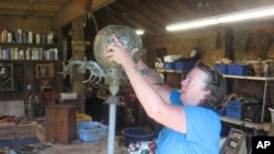 Mississippi artist Lori Gordon works on a new outdoor piece, made from almost all Katrina debris except for a few glass prisms and the hardware holding it together.