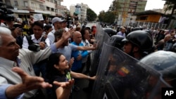 Venezuelan police block a crowd of people gathered to march against the government of President Nicolas Maduro, in Caracas, Venezuela, March 9, 2019.
