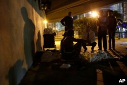 Ron Book, chairman of the Miami-Dade County Homeless Trust, center, kneeling, talks with a homeless couple sleeping under a bridge during the Point In Time Homeless Census, Thursday, Jan. 22, 2015, in Miami. The couple agreed to be sent to a shelter for t