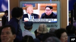 People watch a TV screen showing file footage of U.S. President Donald Trump, left, and North Korean leader Kim Jong Un during a news program at the Seoul Railway Station in Seoul, South Korea, May 16, 2018.