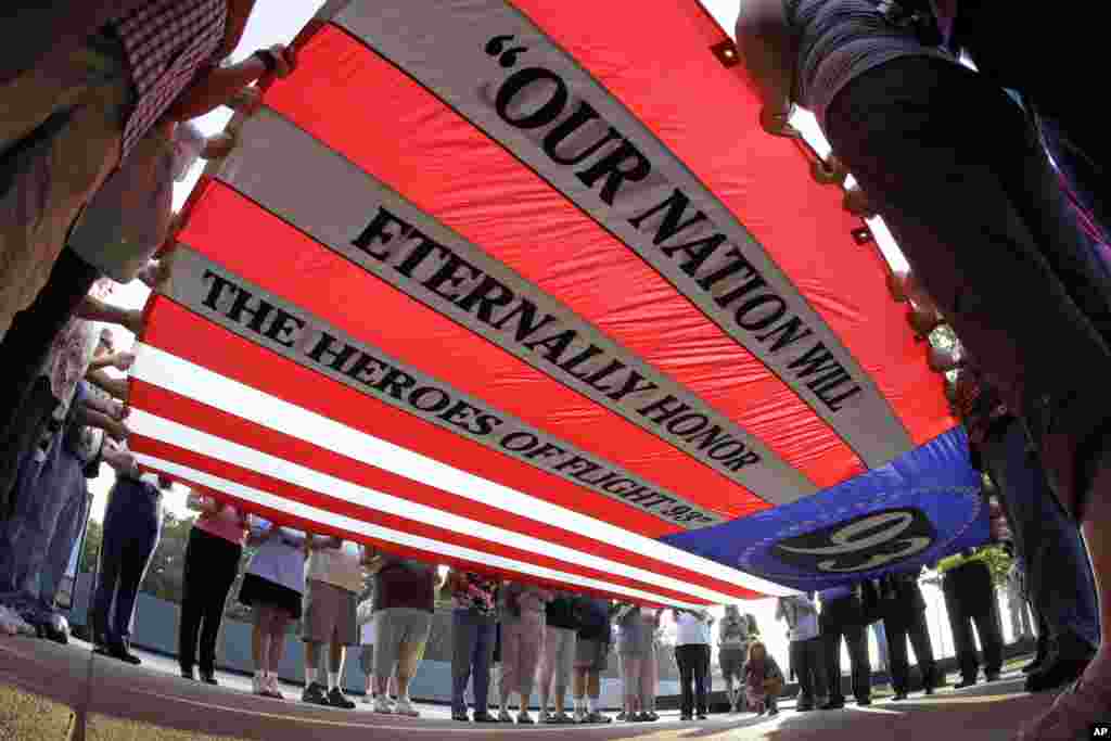 Visitors to the Flight 93 National Memorial participate in a sunset ceremony with a giant flag memorializing Flight 93, Sept. 10, 2013. 