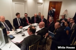 FILE - President Donald Trump receives a briefing on a military strike on Syria from his National Security team on Thursday April 6, 2017, in a secured location at Mar-a-Lago in West Palm Beach, Florida.