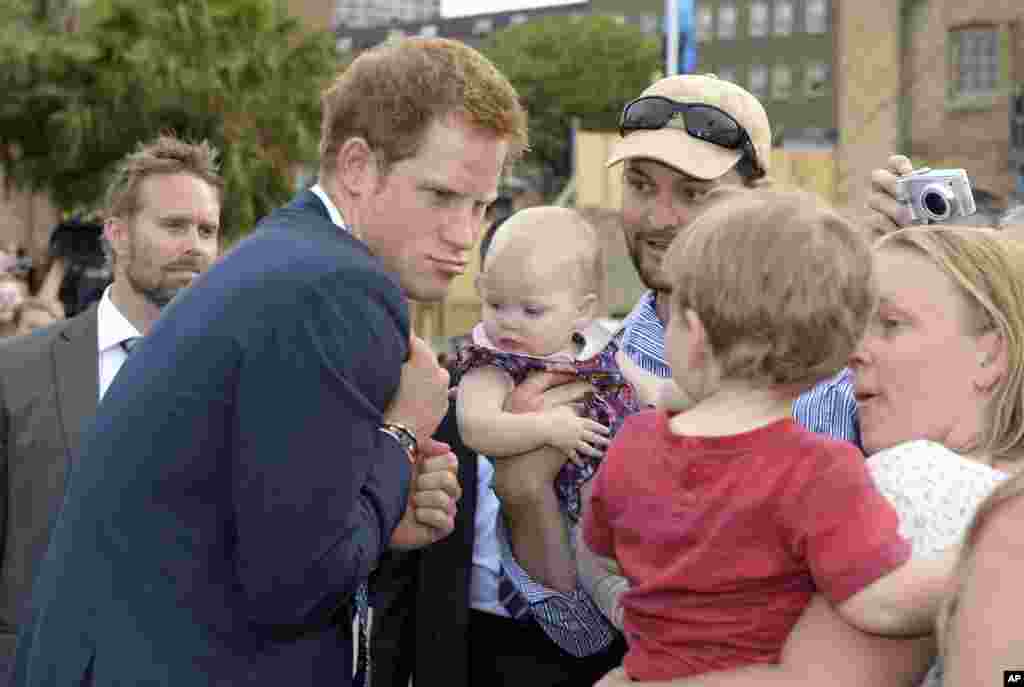 Prince Harry makes a funny face at a young child as he is greeted by a large crowd during the International Fleet Review in Sydney.