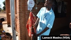 A medical worker weighs a potentially malnutrition child at Mbela health centre in Balaka district, Malawi.