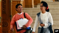 FILE - Myanmar opposition leader Aung San Suu Kyi, right, and Zeyar Thaw, a parliament member of her National League for Democracy party, leave a regular session of Lower House parliament in Naypyitaw, Myanmar, Dec. 3, 2015. 