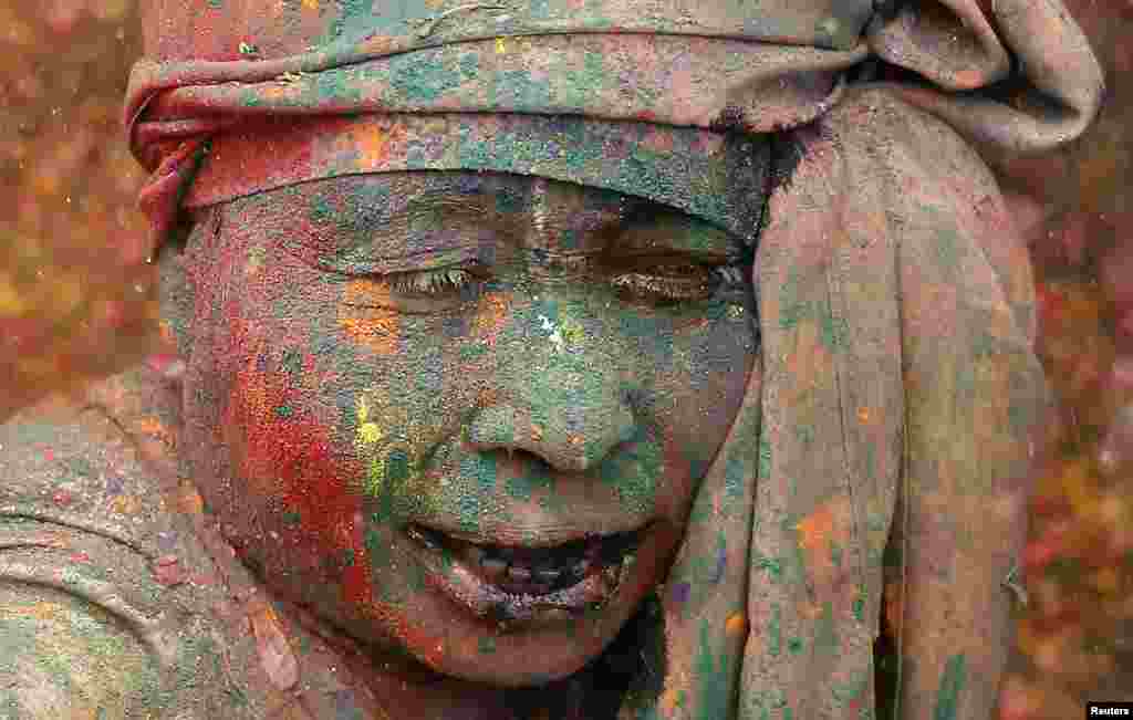 A widow daubed in paint sings religious songs as she takes part in the Holi celebrations organized by Sulabh International, a non-governmental organization, at a temple at Vrindavan, in the northern state of Uttar Pradesh, India.