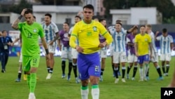 Geovane (21) y el portero Matheus Donelli (12), de Brasil, salen del campo después de perder 1-0 contra Argentina en el último partido clasificatorio de sudamérica para los Juegos Olímpicos en el estadio Brigido Iriarte, en Caracas, Venezuela, el domingo 11 de febrero de 2024.