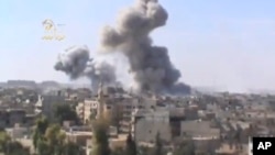 FILE - Plumes of smoke rise from explosions in Deir el-Zour, 450 km northeast of Damascus, Syria, Oct. 29, 2012. Islamic State militants have reportedly launched an attack on government-held areas of the city.