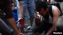 Supporters of deposed Egyptian president Mohamed Mursi mourn protesters who died during clashes with army soldiers as they touch blood on the ground in Cairo, July 8, 2013.