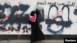 A protester sprays an anti-government graffiti during clashes in the Manama neighborhood of al-Bilad al-Qadeem, April 26, 2012. 