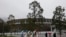 People walk past the Olympic rings near the New National Stadium in Tokyo, March 4, 2020. 