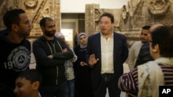 FILE - Stefan Weber, director of the Museum for Islamic Art (C), talks to refugees during a special tour of the complex, in Berlin, Germany, Dec. 16, 2015.