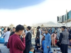 Afghans crowd near the tarmac of the Kabul airport on Aug. 16, 2021, as they try to flee the country.